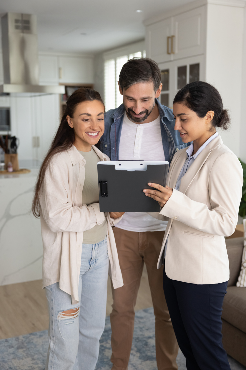 Real estate agent showing document to smiling couple Real estate agent showing document to smiling couple